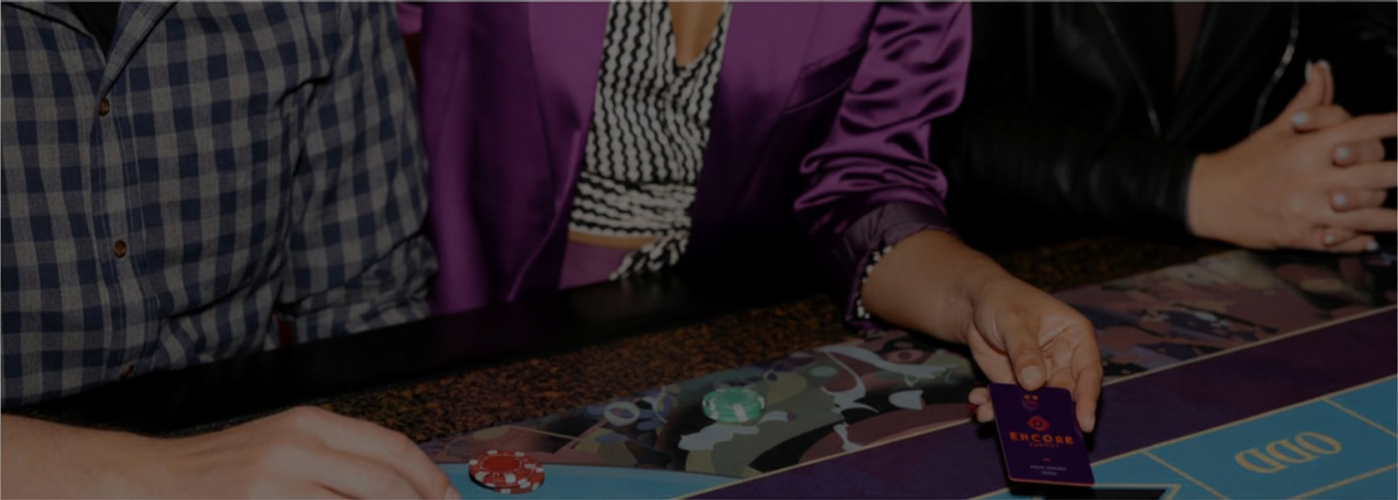 people playing table games at a casino where one is a member of Encore rewards